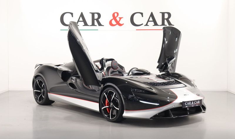 McLaren Elva nera e bianca con le porte aperte nello studio Car & Car